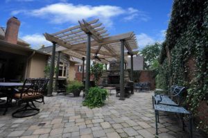 The addition of a outdoor seating area with a pergola, an outdoor fireplace, and a reconfigured landscape after the removal of a pool.
